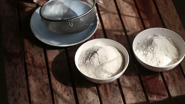 closeup of wheat and rye flour and bolter standing on wooden tab