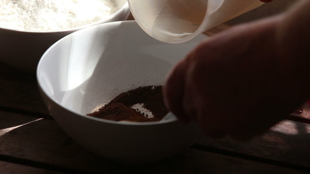 caucasian woman hand pours water into bowl with malt	