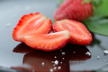 Fresh strawberries on black floor and reflex