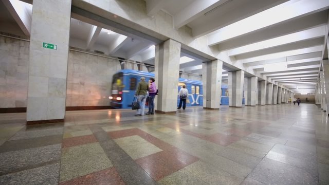 Train arrives at metro station with several passengers