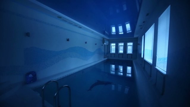 Turning off lights in indoor pool with clear water in big room