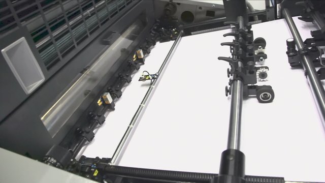 Wide white paper in printing conveyer, closeup view