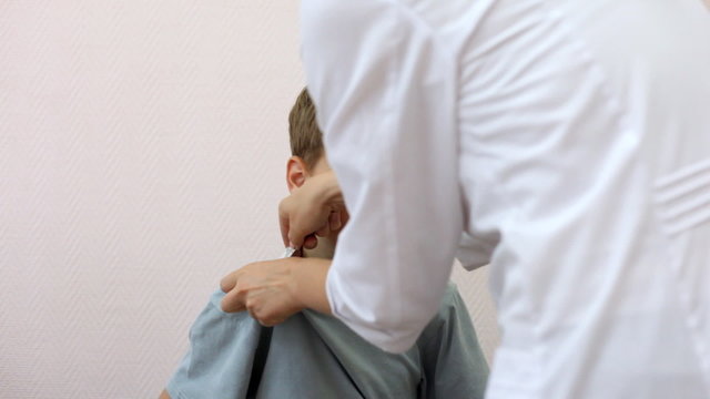 doctor in white dressing gown gives to boy thermometer to armpit