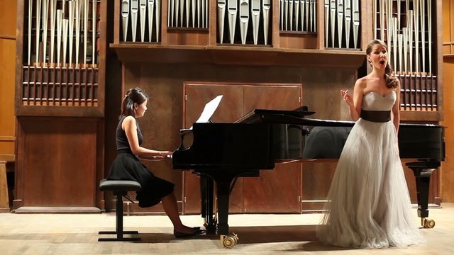 Woman pianist plays the piano and elegance singer sing