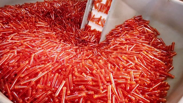 Big pile of small orange blanks to create plastic beer bottles