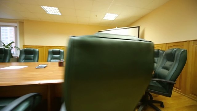 Long table with black armchairs in room for business meetings