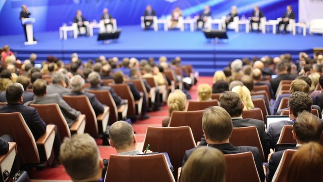 Back view rows seats with listeners sitting in large a hall