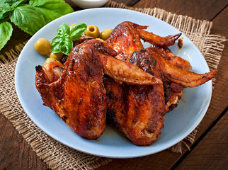Plate of chicken wings on wooden background