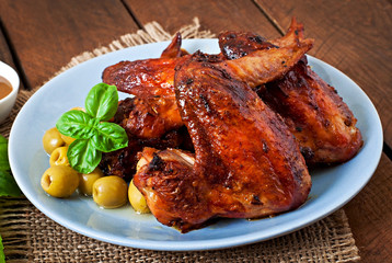 Plate of chicken wings on wooden background