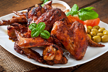 Plate of chicken wings on wooden background
