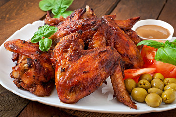 Plate of chicken wings on wooden background