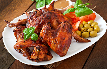 Plate of chicken wings on wooden background