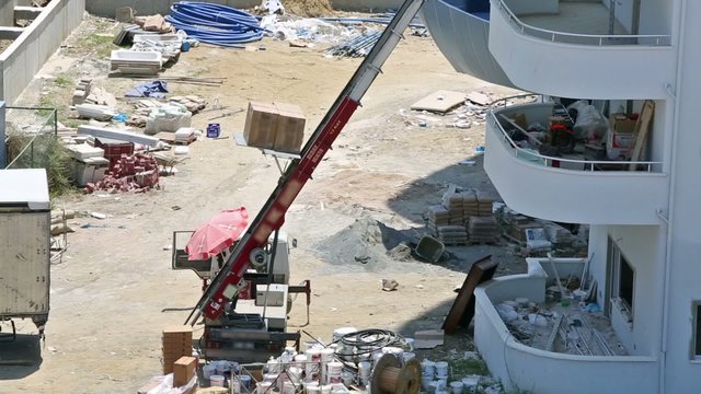 Builders raise materials on the third floor through lift machine