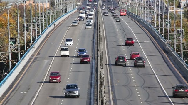 Many modern cars go on bridge at sunny day in Moscow, Russia