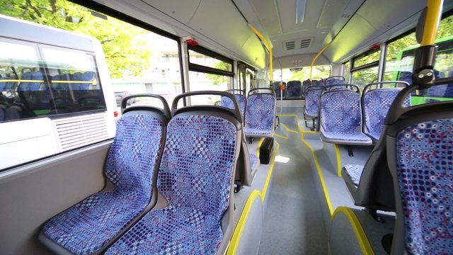 Rows of empty seats inside saloon of empty city bus