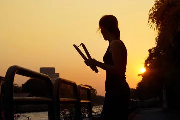 Fotobehang Vechtsport women and nunchaku in hands silhouette in sunset, martial arts