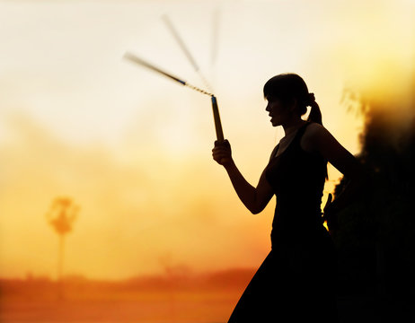 martial arts, women and nunchaku in hands silhouette in sunset - Powered by Adobe