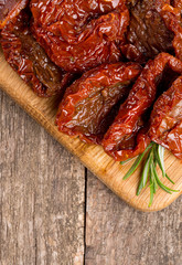 sun dried tomatoes with olive oil on wooden surface