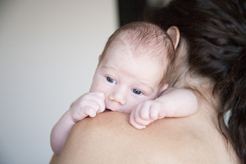 newborn baby on mother shoulder