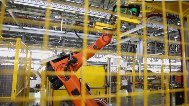 Motion of robotics which weld car components at factory workshop