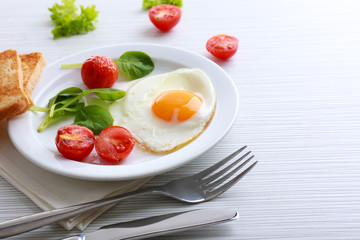 Bacon and eggs on color wooden table background