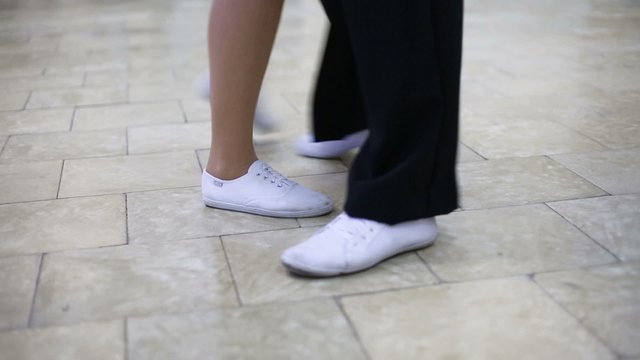 Legs of man and woman dancing boogie-woogie on marble floor