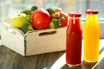 Bottles of juice with fruits and vegetables  in crate