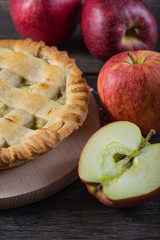 Apple pie and fresh apples on table