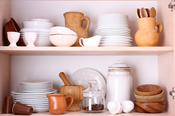 Kitchen utensils and tableware on wooden shelves
