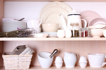 Obraz na płótnie Canvas Kitchen utensils and tableware on shelves