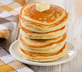 Stack of Small pancakes on a white wooden table