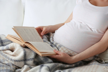 Young pregnant woman lying on sofa close up