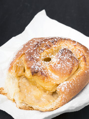 Sweet bun on black wooden background