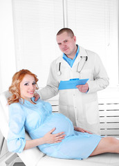 Obraz premium Young pregnant woman with doctor in hospital