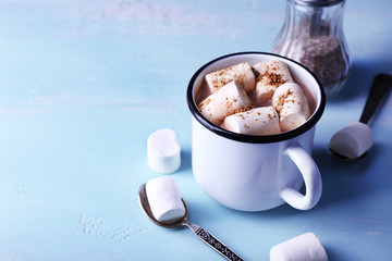 Mug of cocoa with marshmallows on wooden table background