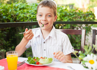 Child eating salad at a cafe