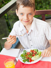 Child eating salad at a cafe