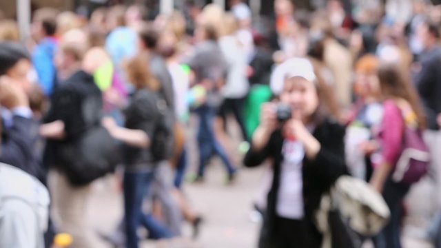 Soap balloons fly against crowd of people walk by street