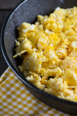 scrambled eggs in vintage frying iron pan, overhead view