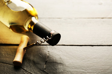 Obraz na płótnie Canvas Glass bottle of wine with corkscrew on wooden table background