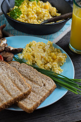 eating healthy breakfast, scrambled egg with chives and fresh ju