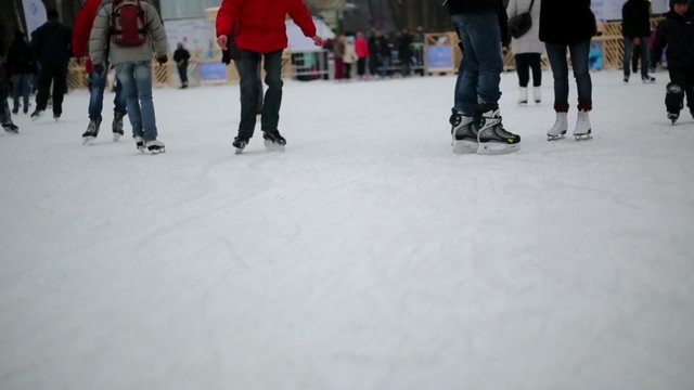 People have rest at skating rink on witer day in park.