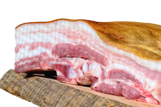 A piece of bacon in a cut on a wooden board