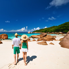 Couple in green walking on a beach at Seychelles