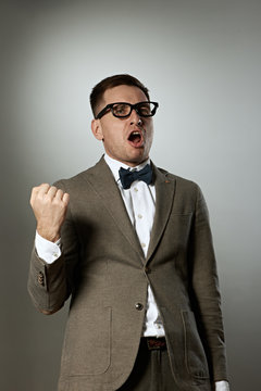 Confident nerd in eyeglasses and bow tie enjoying success