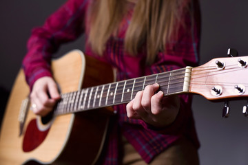 woman's hands playing acoustic guitar