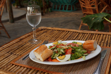 Hard boiled egg with vegetable salad and baguette
