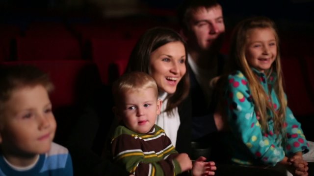 Children and adults watch family comedy at the cinema