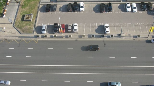 Aerial view of car traffic on street at day and parking lot
