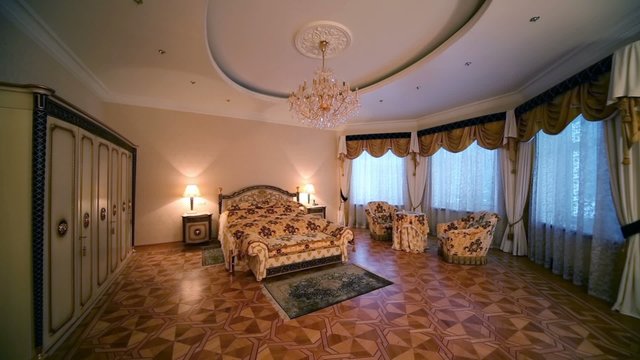Turning off in bedroom with double bed and armchairs